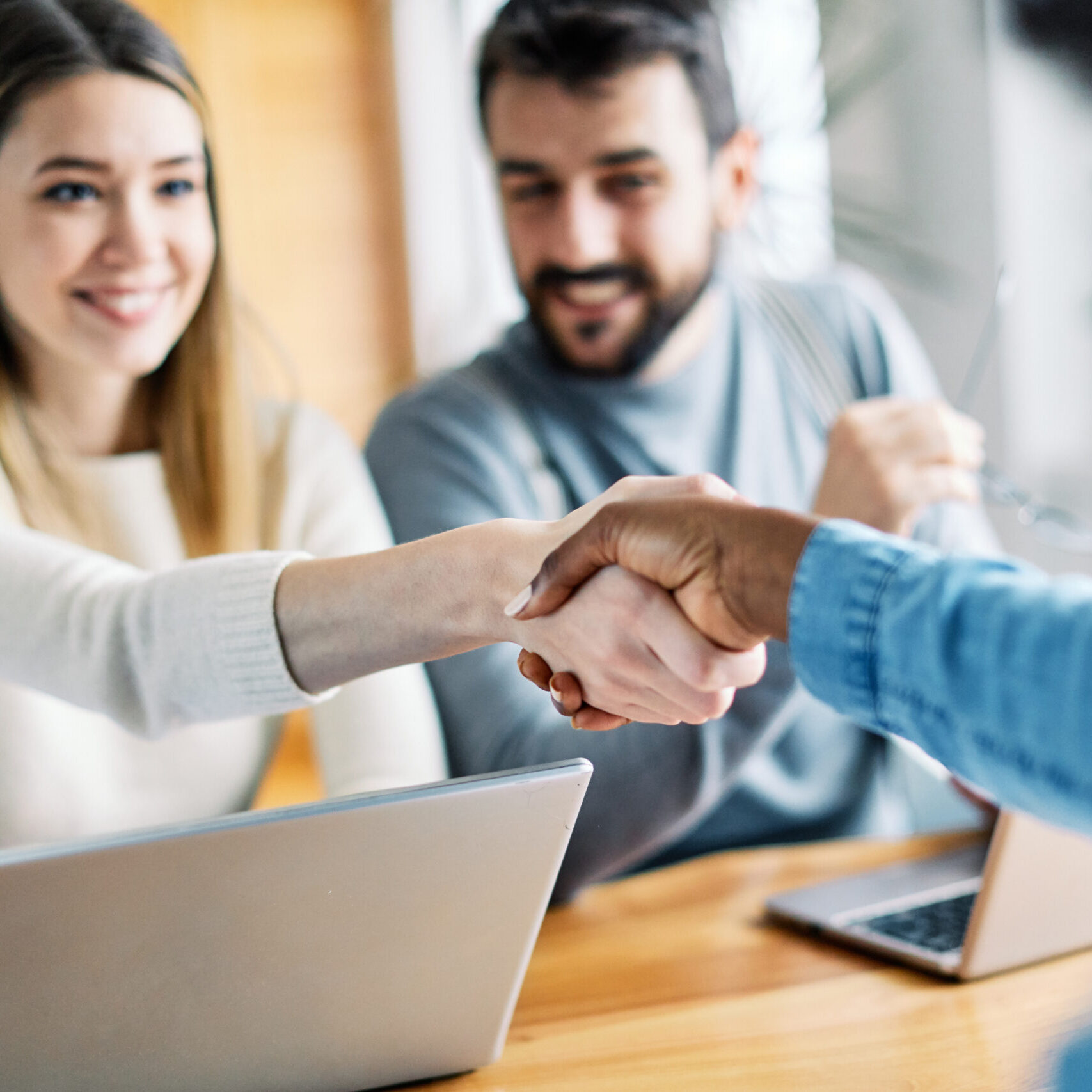 young couple shaking hands deal contract real estate investment Real estate agent with couple shaking hands closing a deal